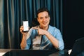 Trader in casual looking at camera stock with pointing smartphone. Pecuniary.