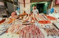 Trader of seafood selling fish and octopus at local street market