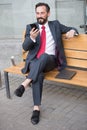 Trader sitting on bench and make deal. Businessman using wireless technology managing corporate processes. Modern Business life