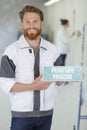 tradesman holding peinture fraiche sign Royalty Free Stock Photo