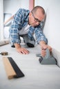 tradesman laying down linoleum flooring Royalty Free Stock Photo