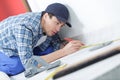 Tradesman laying down linoleum flooring