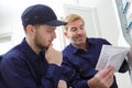 tradesman looking at instruction book by circuit breaker box