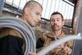 tradesman showing cable trunking to young apprentice Royalty Free Stock Photo