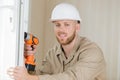 tradesman using cordless screwdriver to work on pvc door Royalty Free Stock Photo