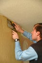 Tradesman wallpapering a room