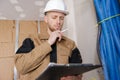 Tradesman wearing uniform looking at clipboard