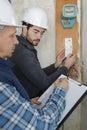 Tradesmen installing distribution board