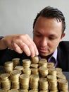 economic growth, young businessman stacking mexican coins of ten pesos Royalty Free Stock Photo