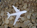 investment in travel, figure of a white plastic plane and coins of ten mexican pesos