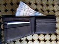 stacked coins of ten mexican pesos and black leather wallet with banknotes of 500 pesos Royalty Free Stock Photo