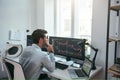 Trading on world markets. Young stock market broker analyzing data and graphs on multiple computer screens while sitting Royalty Free Stock Photo