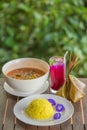 Tradition Thai food on wooden table, Turmeric Rice, Acacia leave omelet and shrimp in spicy sour soup left Butterfly pea juice