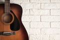 Traditional acoustic guitar in the interior next to the white brick wall Royalty Free Stock Photo