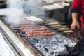 Traditional Adana kebab on a barbecue with smoke, close up