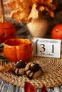 Traditional aesthetic autumn Halloween cookies in shape of spider and cup of tea in shape of pumpkin. 31 of October on
