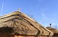 Traditional African thatched roof against a blue sky