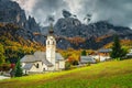 Traditional alpine church and street view with mountains, Dolomites, Colfosco Royalty Free Stock Photo