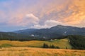 Traditional alpine house  and mountain pastures at sunset in summer. Panoramic view on Mountain valley, summits,  meadows and Royalty Free Stock Photo