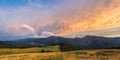 Traditional alpine house  and mountain pastures at sunset in summer. Panoramic view on Mountain valley, summits,  meadows and Royalty Free Stock Photo