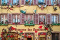 Traditional Alsatian restaurant, with cheerful and romantic decorations on the facade, Colmar, France