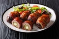 Traditional American Armadillo eggs stuffed with jalapeno and cheese wrapped in bacon served with salad close-up on a plate on the Royalty Free Stock Photo