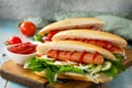 Traditional american fast food. Barbecue grilled Hot dog with fresh vegetables on wooden table. Royalty Free Stock Photo