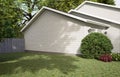 Traditional American home with two garages, a driveway and a large tree.