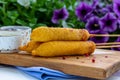 Traditional American street food corn dogs with mustard and ketchup on wooden table. Royalty Free Stock Photo