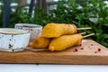 Traditional American street food corn dogs with mustard and ketchup on wooden table. Royalty Free Stock Photo