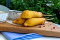 Traditional American street food corn dogs with mustard and ketchup on wooden table. Royalty Free Stock Photo