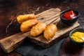 Traditional American street junk food Deep fried corn dogs with mustard and ketchup. Dark background. Top view Royalty Free Stock Photo