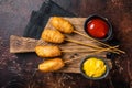 Traditional American street junk food Deep fried corn dogs with mustard and ketchup. Dark background. Top view Royalty Free Stock Photo