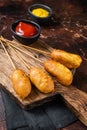 Traditional American street junk food Deep fried corn dogs with mustard and ketchup. Dark background. Top view Royalty Free Stock Photo