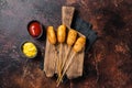 Traditional American street junk food Deep fried corn dogs with mustard and ketchup. Dark background. Top view Royalty Free Stock Photo