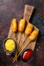 Traditional American street junk food Deep fried corn dogs with mustard and ketchup. Dark background. Top view Royalty Free Stock Photo