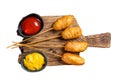 Traditional American street junk food Deep fried corn dogs with mustard and ketchup. Isolated, white background. Royalty Free Stock Photo