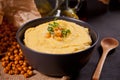 Traditional appetizer hummus with chickpea in a black bowl