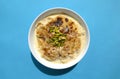 Traditional Arabic, oriental dessert Om Ali. Top view. Egyptian Bread Pudding in a white bowl on blue background