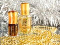 Traditional arabic perfume oil. Perfume oil fragrances in mini bottle on golden and silver background. Holidays decoration. Chris