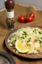 Traditional Arabic salad or Tabbouleh on ceramic plate, healthy vegetarian dish with couscous, tomatoes, parsley, mint
