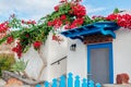 Traditional architecture in Akrotiri village on Santorini island Greece. White house blue doors bougainvillea flowers Royalty Free Stock Photo