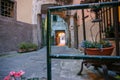 Traditional architecture with cobbled lane leading through archway in evening light with incidental people in distance