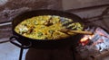 Traditional Argentinean food with chicken and rice in copper pan on the fire