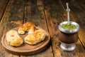 Traditional Argentinian yerba mate tea in calabash gourd and argentine pastries. Royalty Free Stock Photo