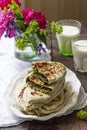 Traditional Armenian flatbread with greens zhengyalov hats, served with yogurt on the background of a bouquet.