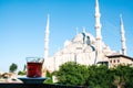Traditional aromatic Turkish black tea in a tulip-shaped glass. In the background, the Blue Mosque is also called Royalty Free Stock Photo