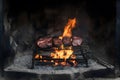 Traditional asado grilling in an ancient, rustic fireplace