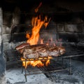 Traditional asado grilling in an ancient, rustic fireplace Royalty Free Stock Photo