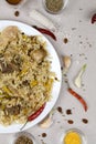 Traditional asian dish - pilaf from from rice, vegetables and meat in white plate on gray background Royalty Free Stock Photo